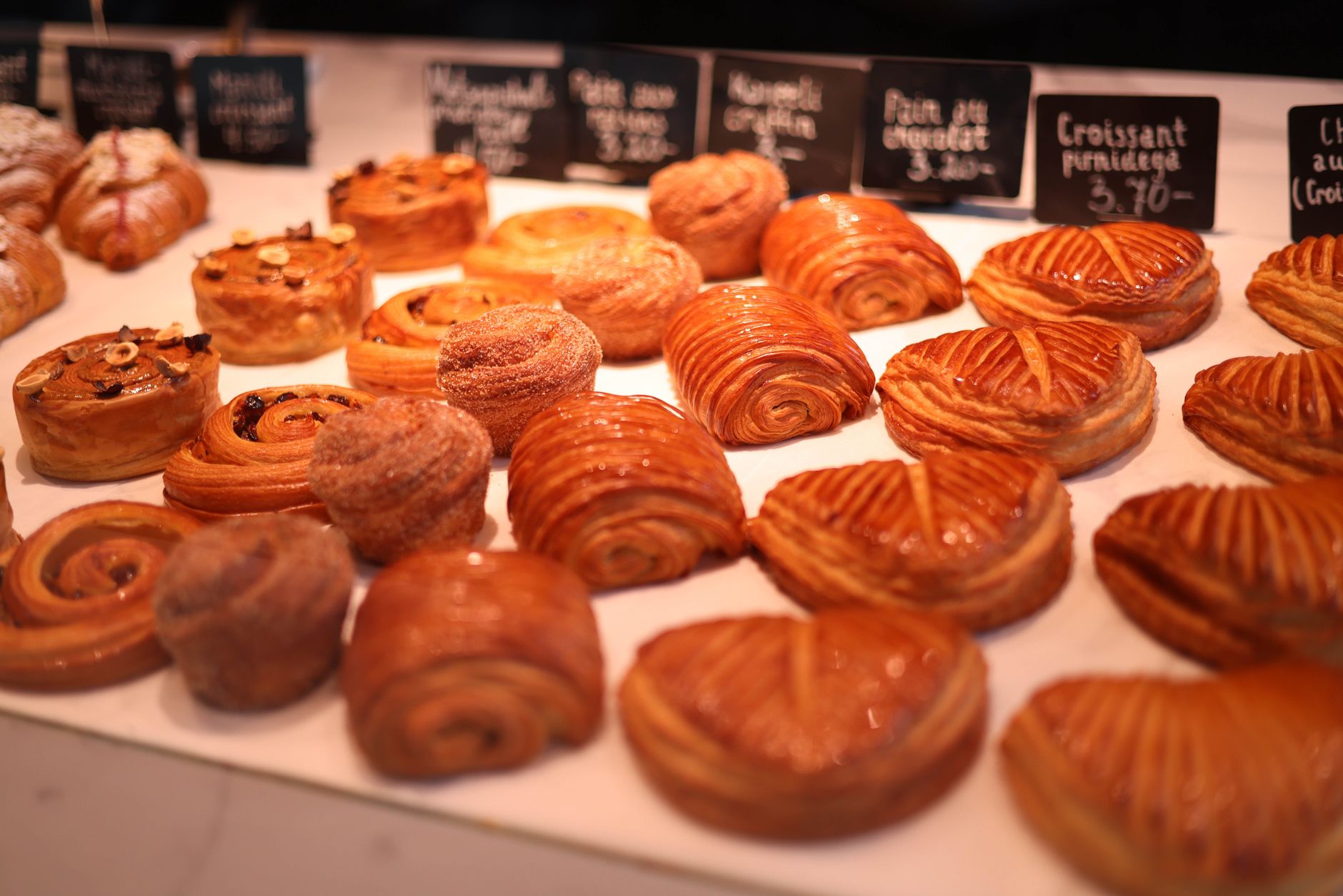 Croissants et viennoiseries dorées présentés en vitrine